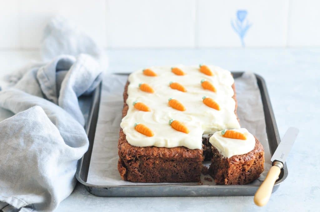 carrot cake on metal tray with blue tea towel