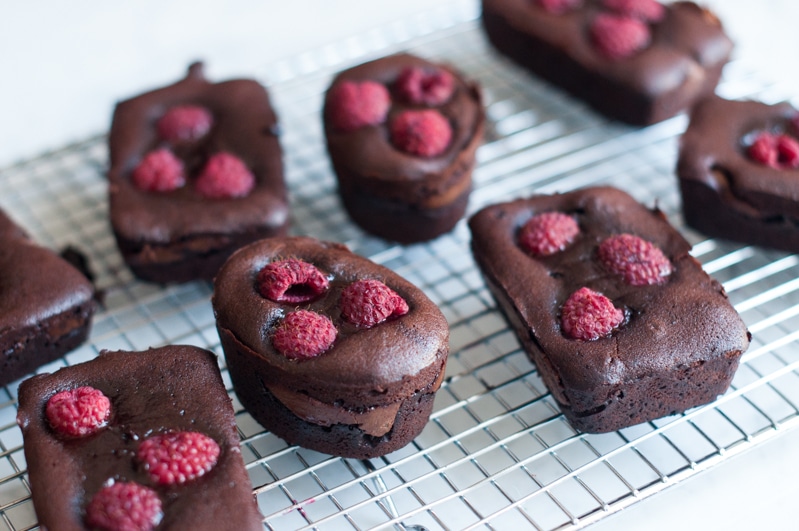 gooey chocolate cakes with nutella and raspberries on wire rack
