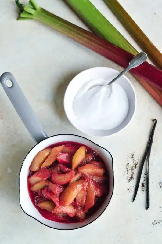 rhubarb compote, stewed rhubarb, in saucepan with bowl of sugar and vanilla bean