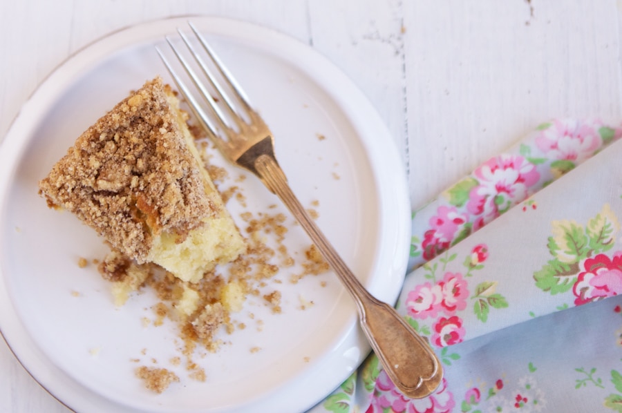 slice of apple crumble cake on white plate with fork