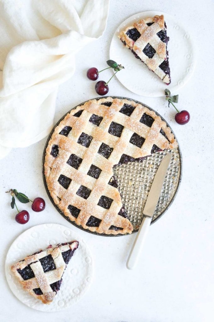 slices of cherry pie with lattice pie crust on white plates