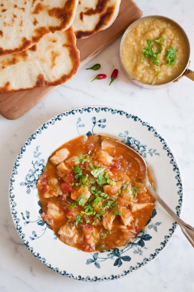 indian chicken curry served with lentil dahl and naan bread