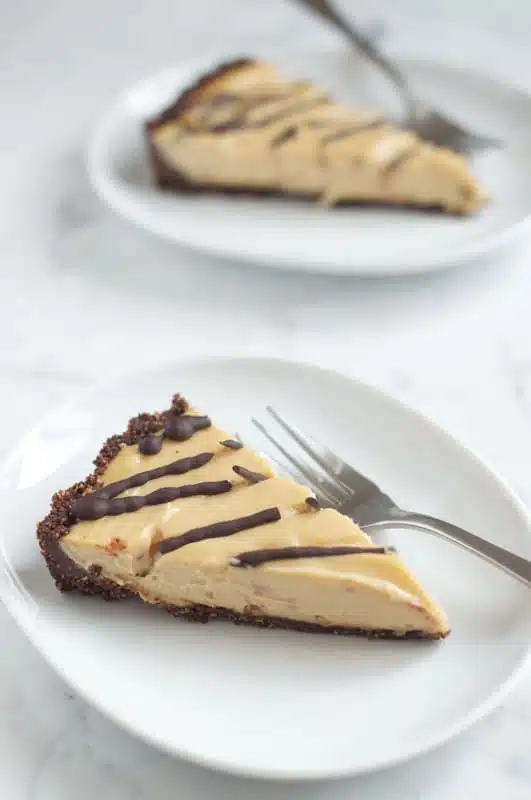 chocolate-peanut-butter-cheesecake-photo-1 slice of chocolate peanut butter cheesecake on white plate