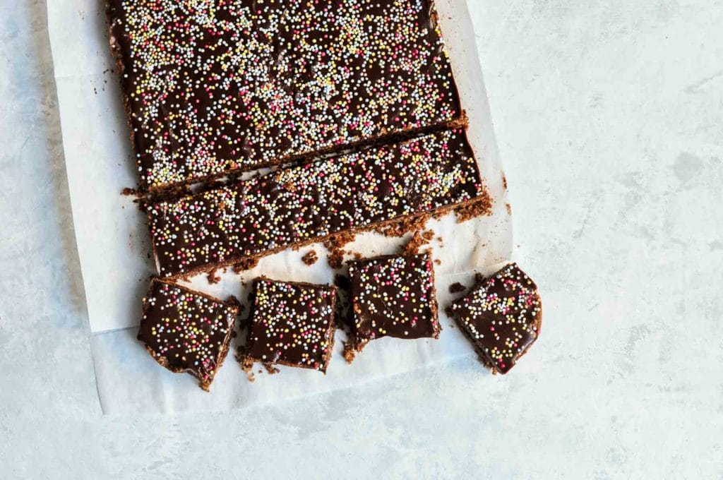 slices of chocolate coconut bars with sprinkles on baking paper