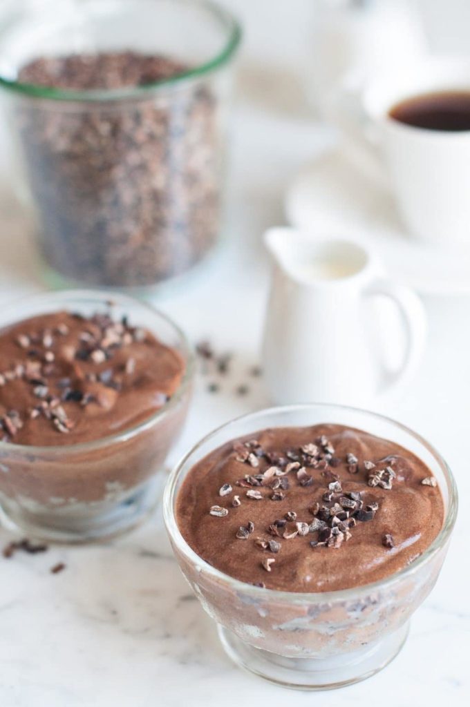 chocolate mousse in small glass bowls with coffee in background