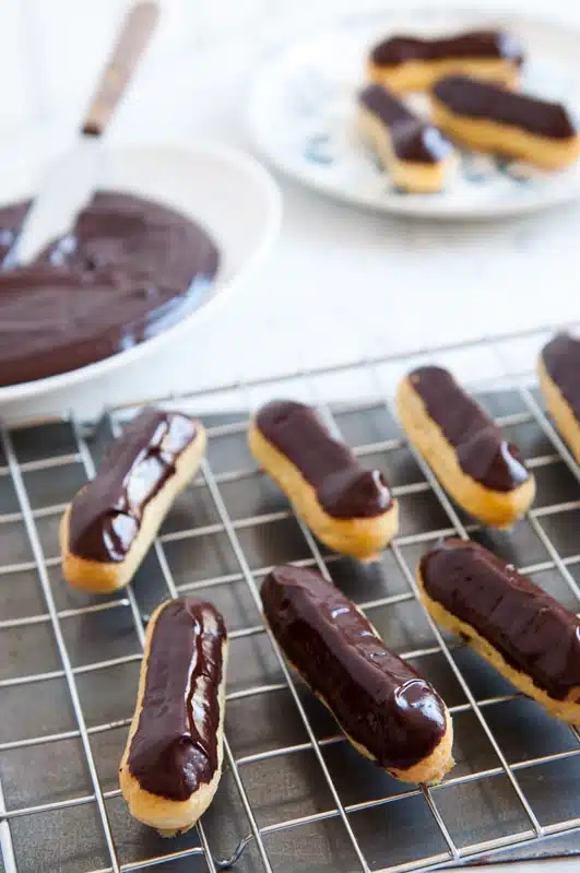 chocolate eclairs on wire rack