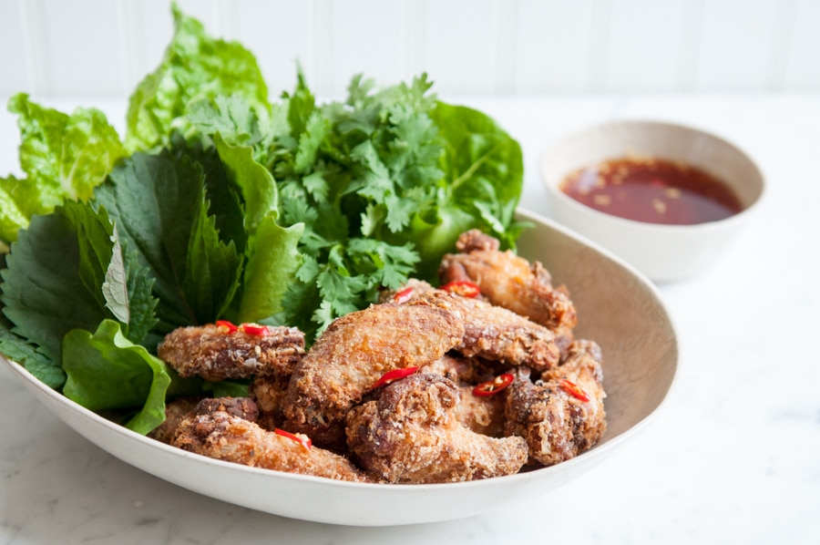 crispy chicken wings with fish sauce in bowl with salad
