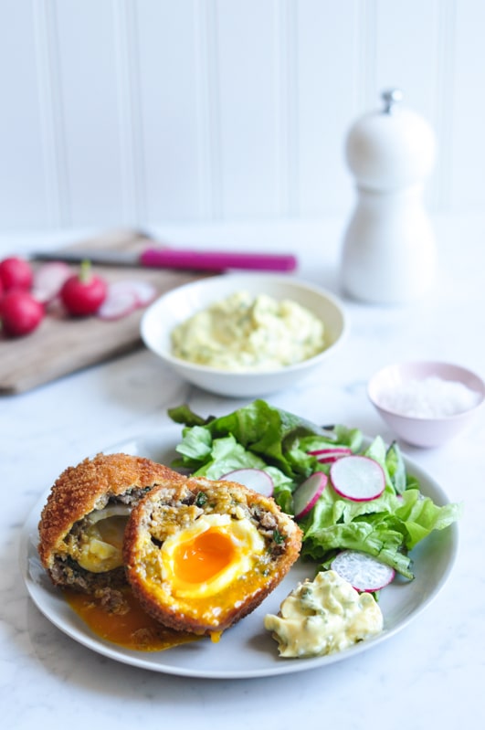 scotch eggs with salad on plate