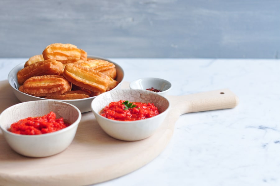 potato churros with bowls of red pepper sauce