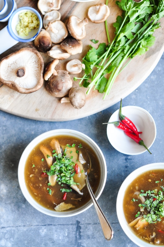 hot and sour soup with fresh ingredients on wooden board