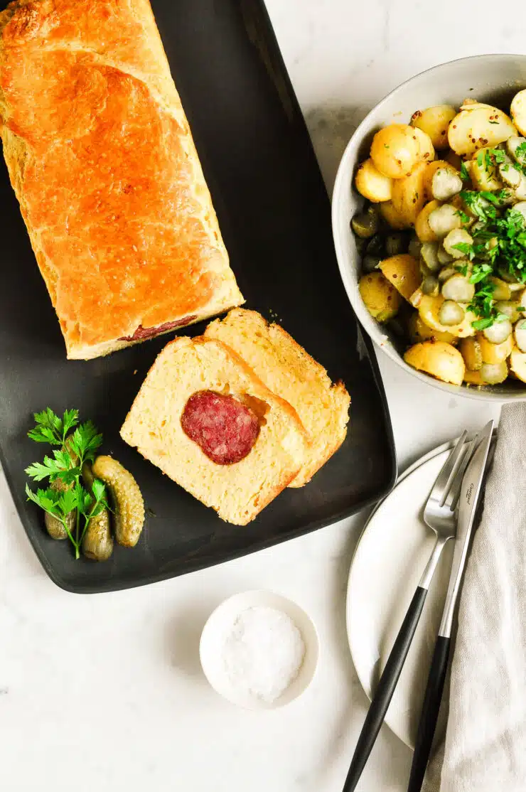 lyonnaise sausage roll sliced with cutlery on plate
