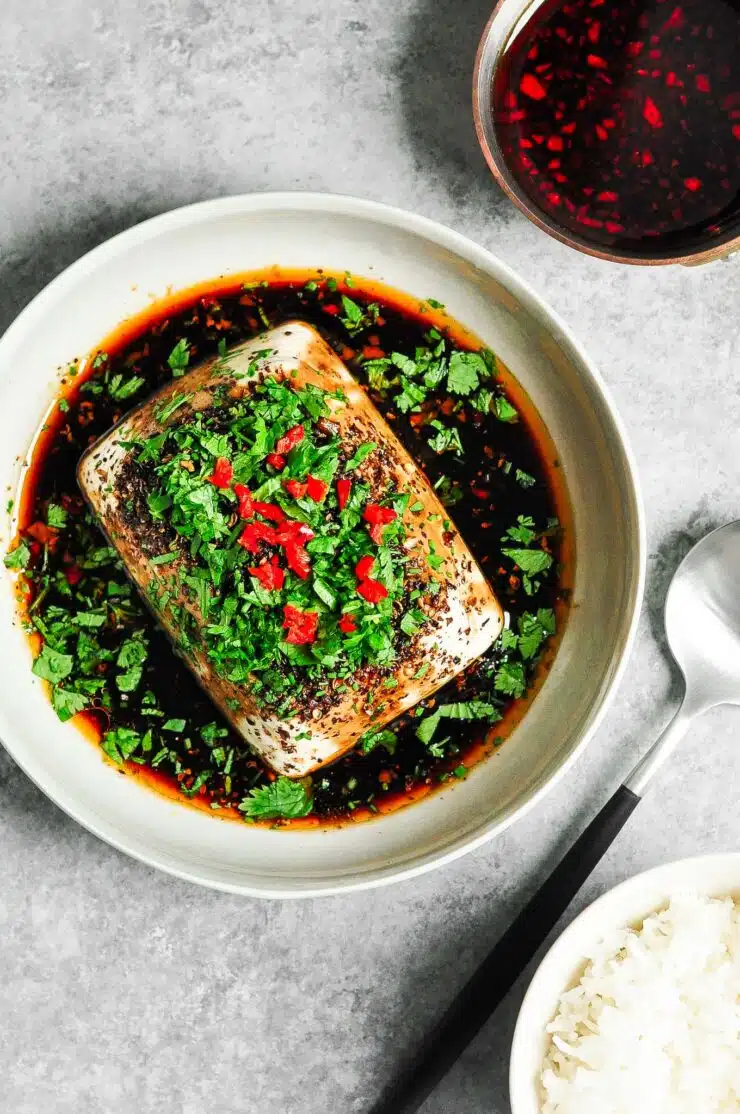 steamed tofu with soy and chillies on plate with spoon