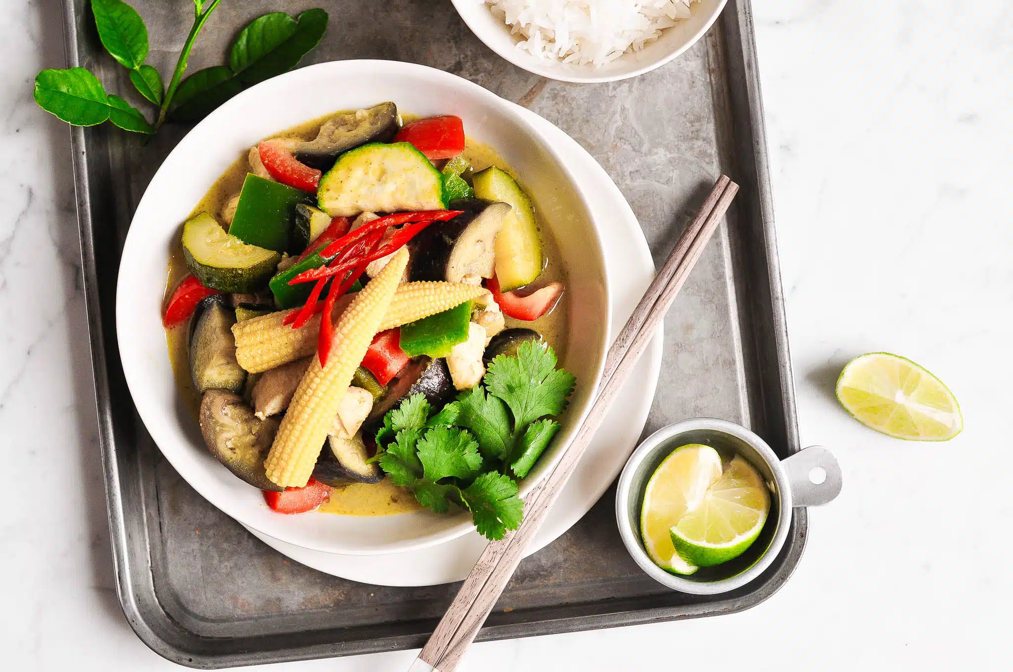thai green curry with vegetables on metal tray