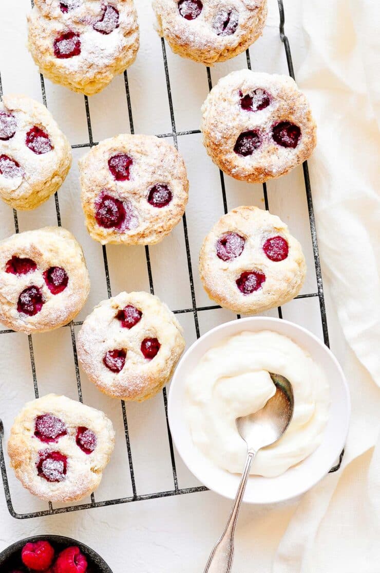 raspberry scones on wire rack with clotted cream
