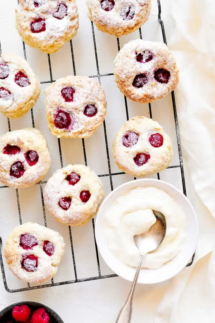 raspberry scones on wire rack with clotted cream