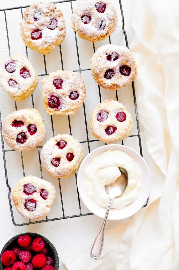 raspberry scones on wire rack with bowl of clotted cream