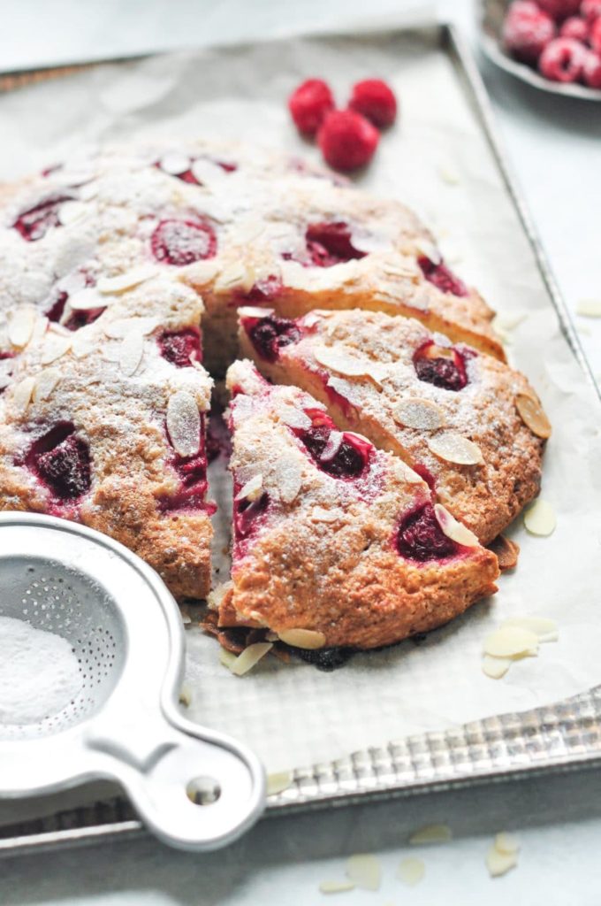 raspberry almond scone slices with icing sugar spoon