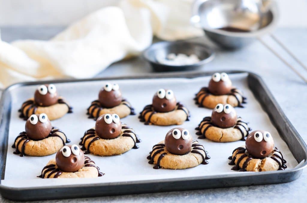 peanut butter spider cookies on metal tray with baking paper