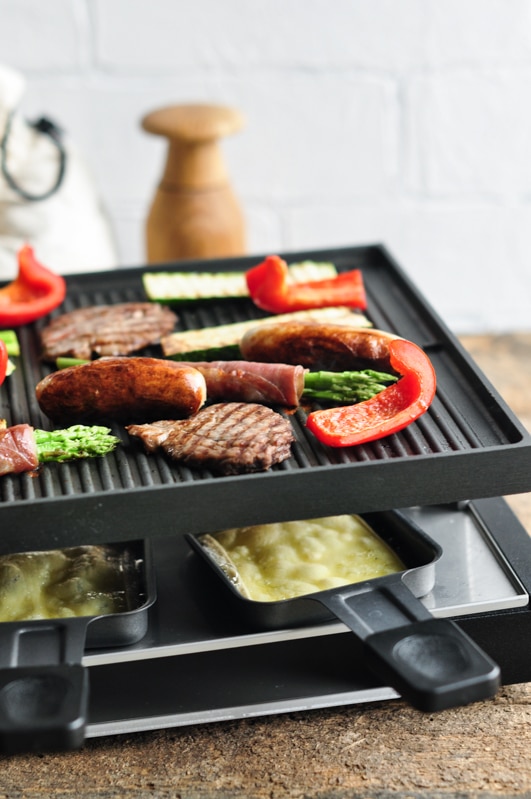 raclette grill with meat vegetables melted cheese