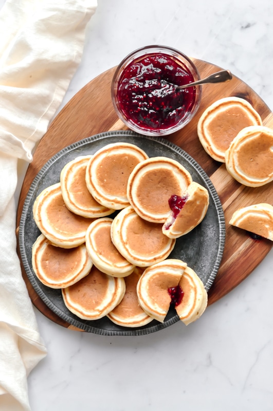 jam-filled pikelets on wooden board with jam