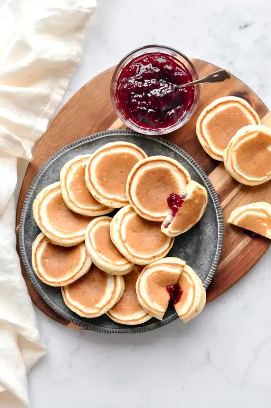jam-filled pikelets on wooden board with jam