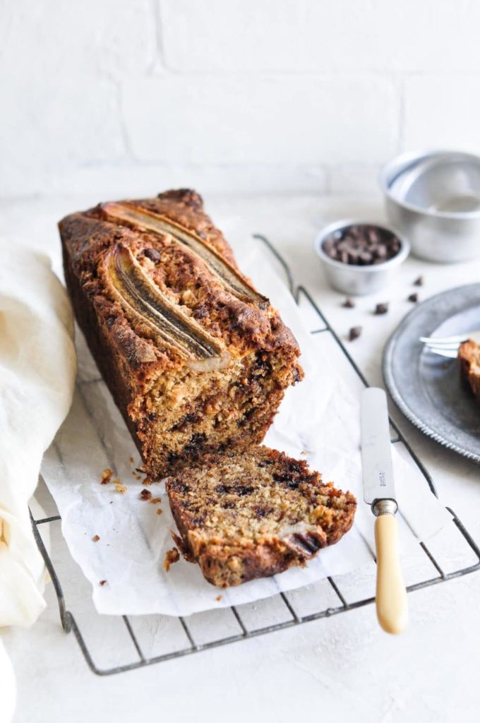 chocolate chip banana bread sliced on baking paper with cake knife
