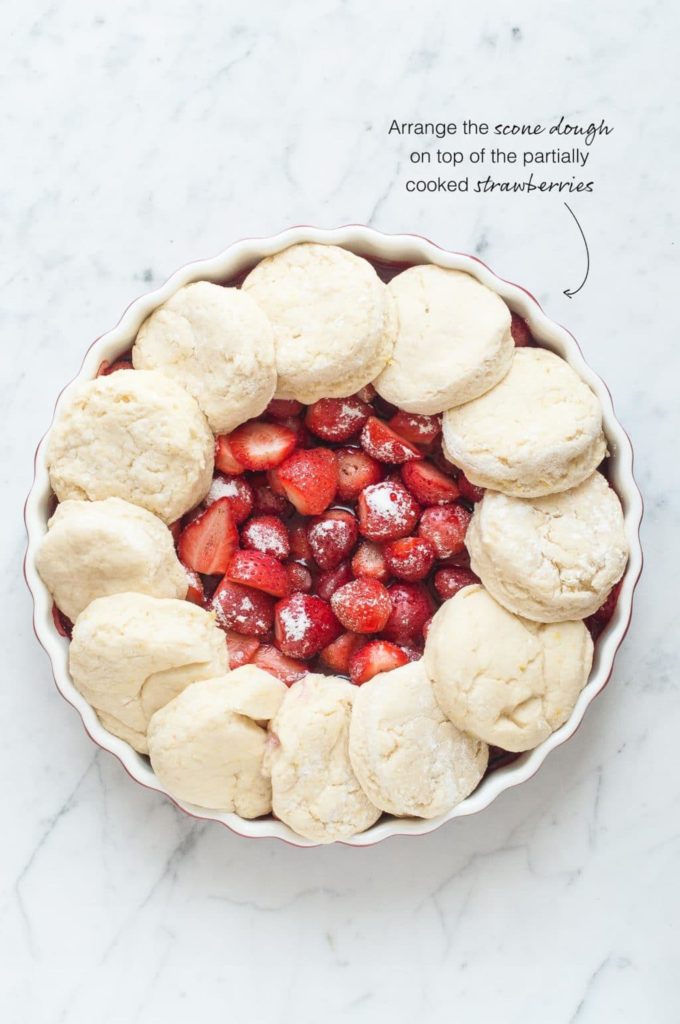 how to make strawberry cobbler, arrange the cobbler topping on top of the cooked strawberries