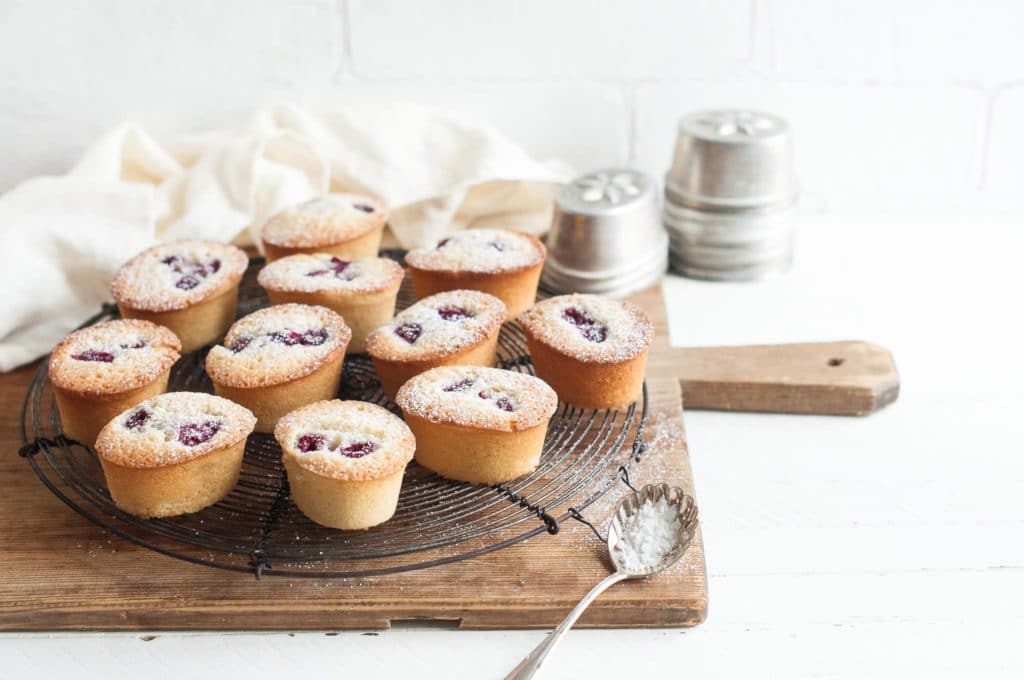 raspberry friands on wire rack on wooden board