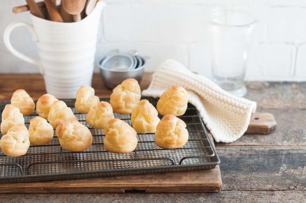 cooked choux buns on a wire rack