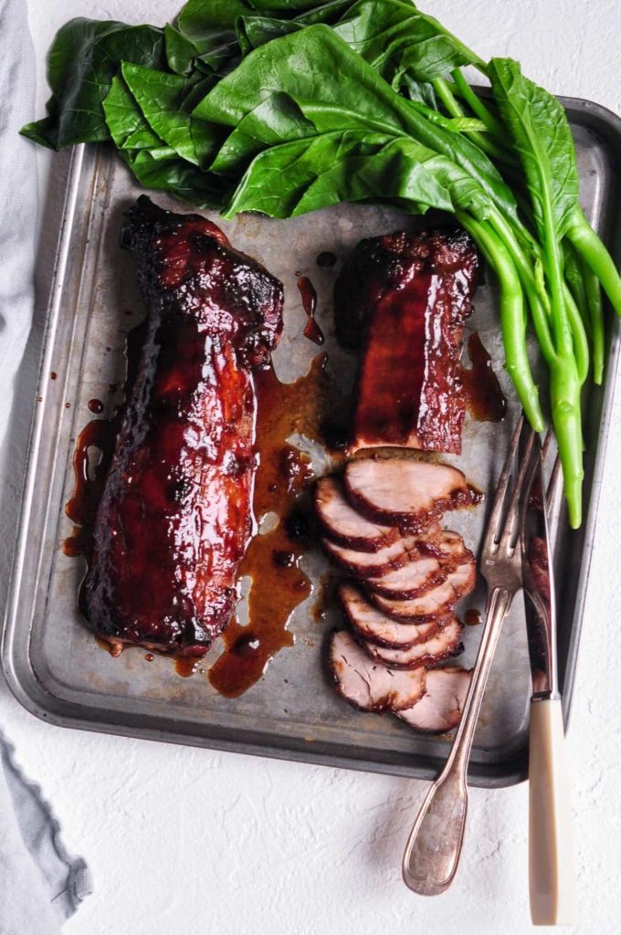 slices of chinese barbecue pork on metal tray with vegetables