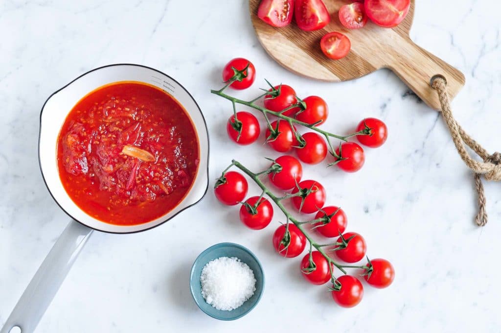 cherry tomato relish in saucepan with fresh cherry tomatoes on vine