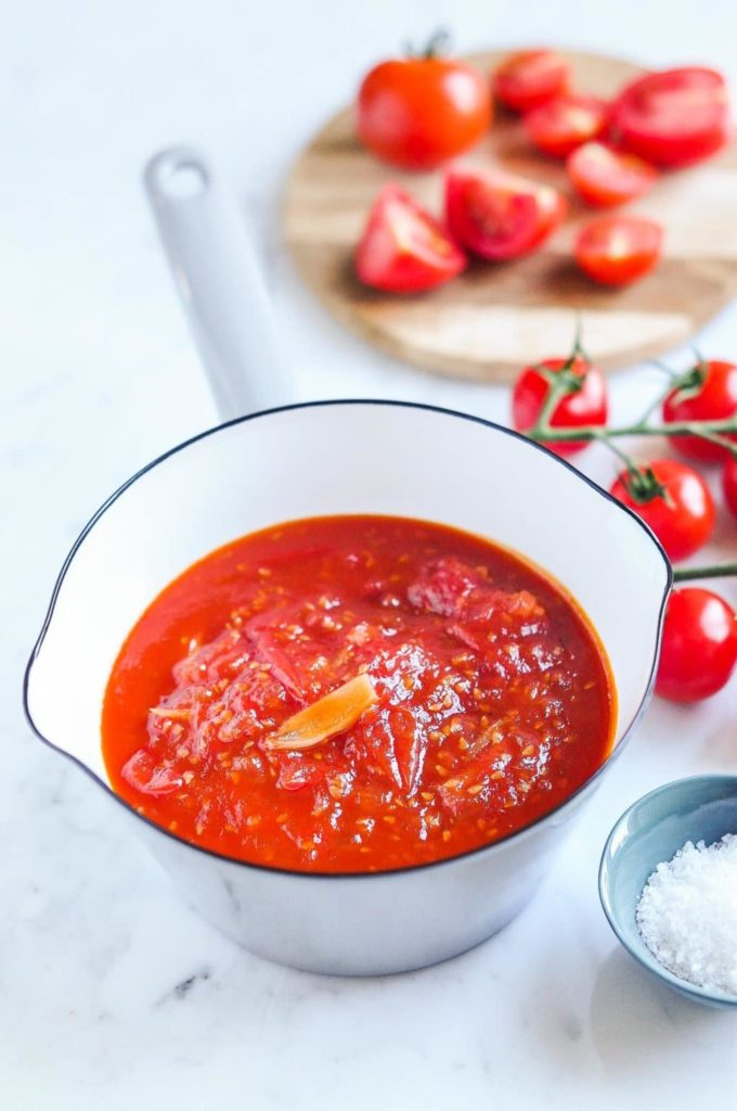 cherry tomato relish in saucepan with fresh cherry tomatoes on vine