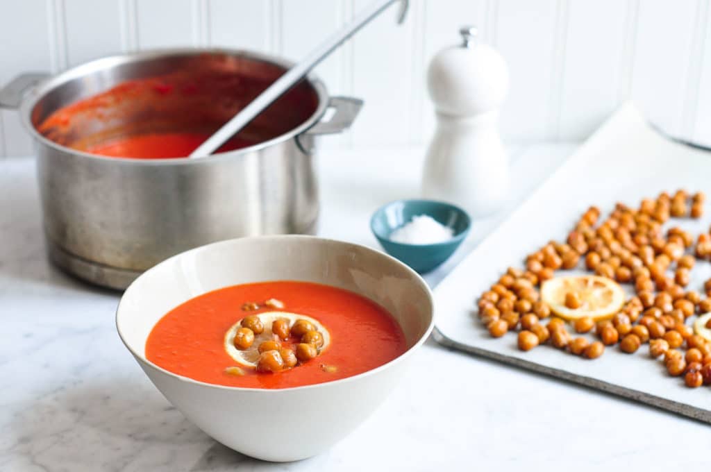 cream of tomato soup in bowl with tray of roasted chickpeas
