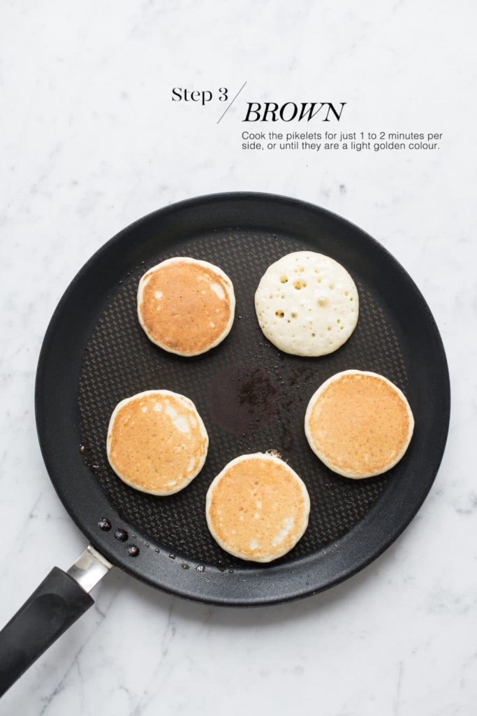 golden pikelets on a non-stick pan