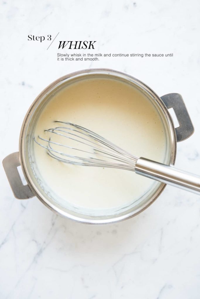 bechamel sauce in saucepan with wire whisk