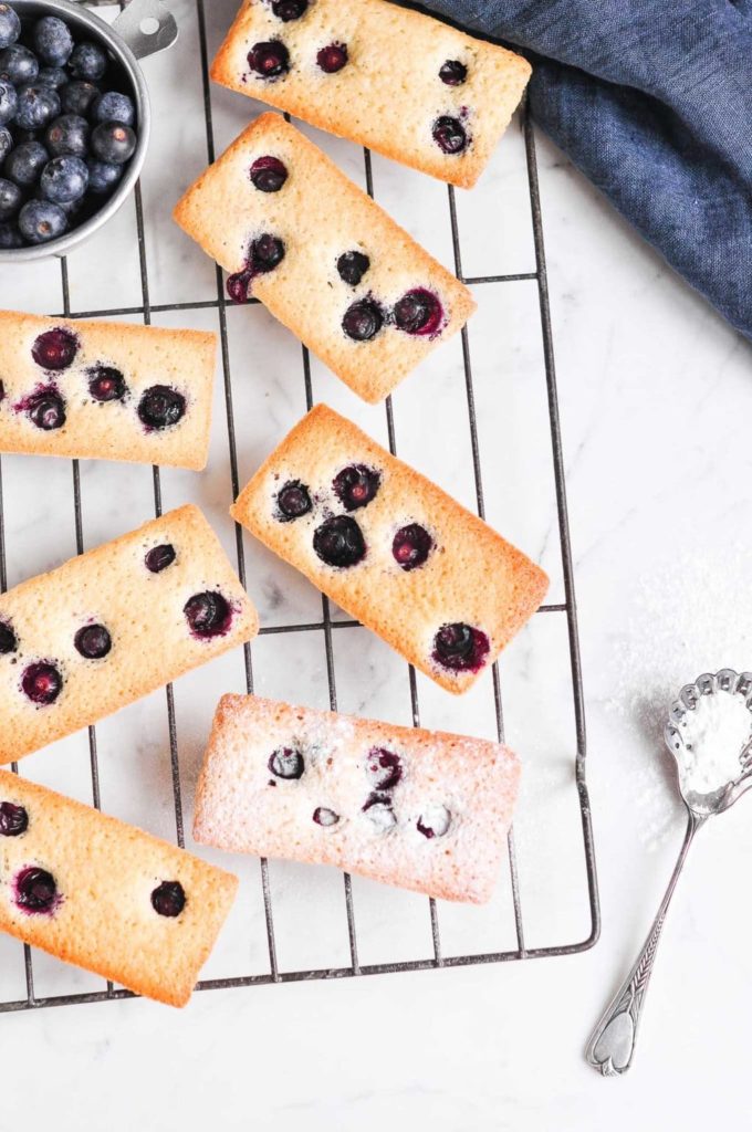 financier cakes with blueberries on cake rack