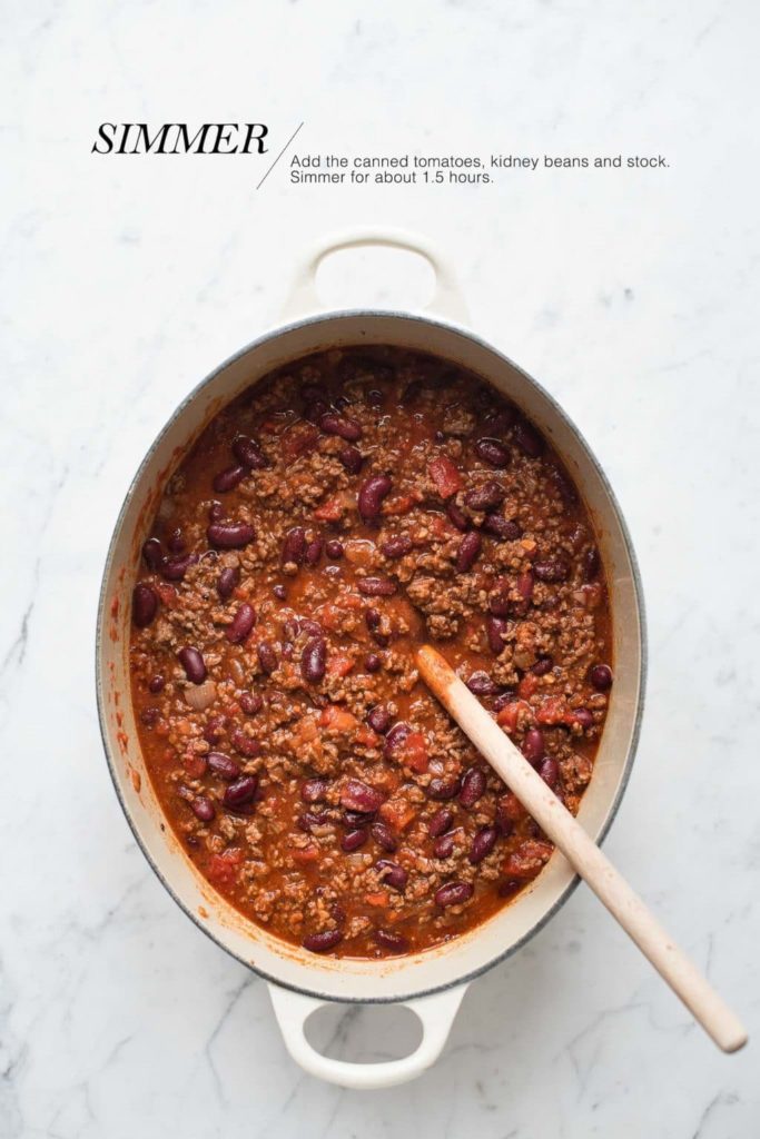 chilli con carne in cast iron pot with wooden spoon