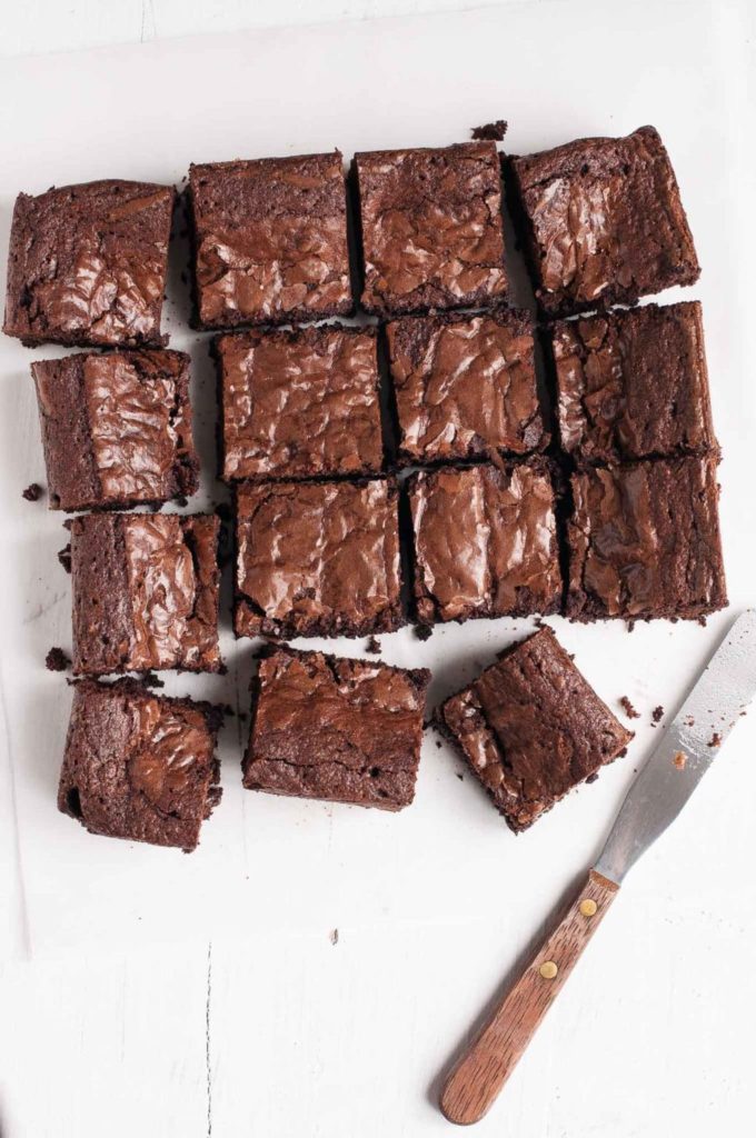 batch of chocolate brownies sliced into squares with palette knife