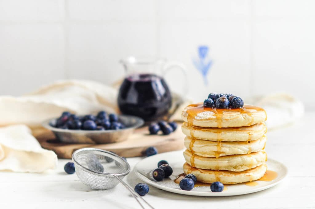easy fluffy pancakes with blueberry sauce on plate