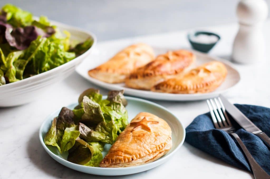 ham and cheese hand pies on blue plate with salad and blue napkin