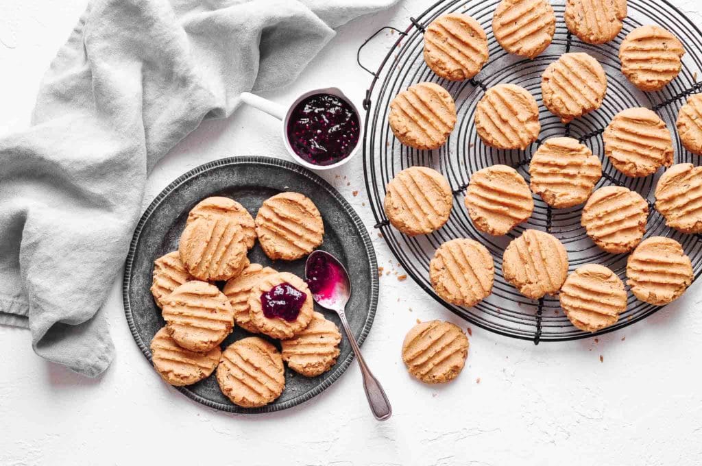 soft peanut butter cookies on wire rack and metal plate with grey napkin
