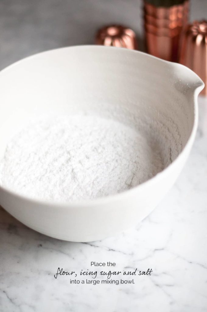 white mixing bowl with flour, icing sugar and salt