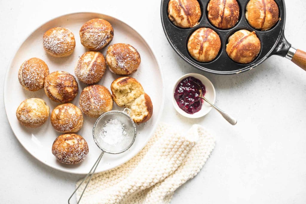 plate of aebleskivers dusted with icing sugar