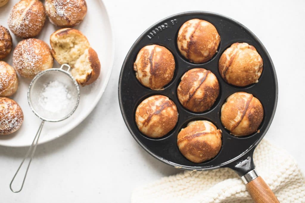cast-iron aebleskiver pan filled with cooked aebleskivers