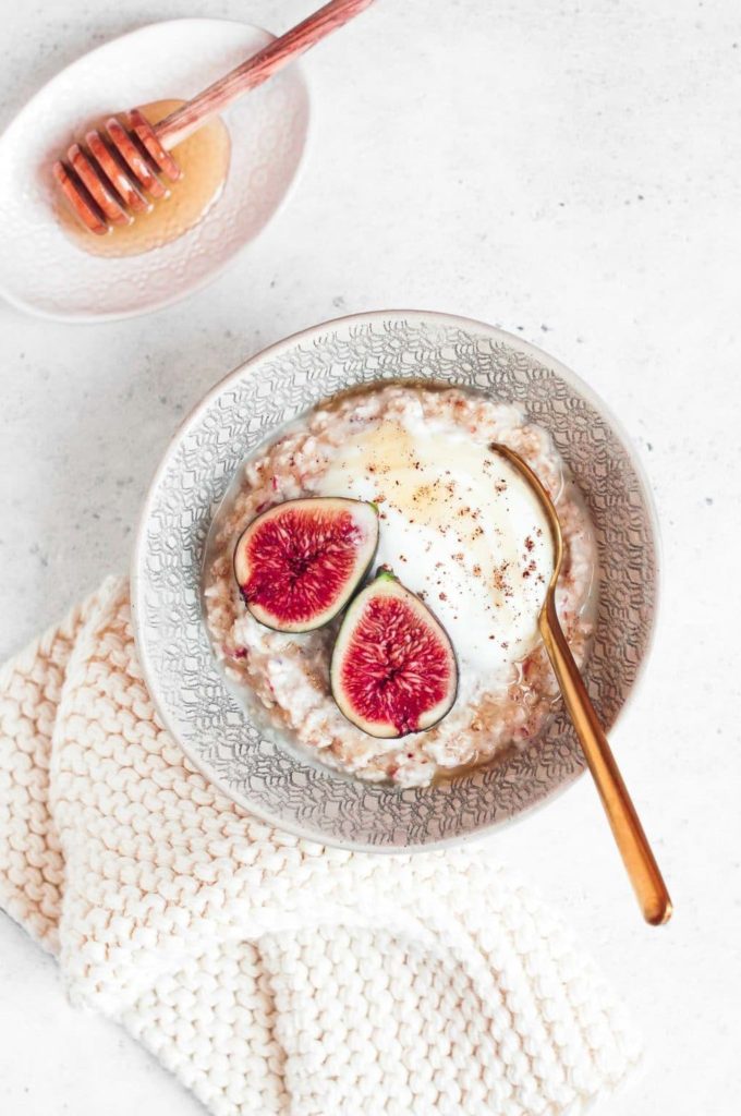 bowl of overnight oats with fresh figs and gold teaspoon