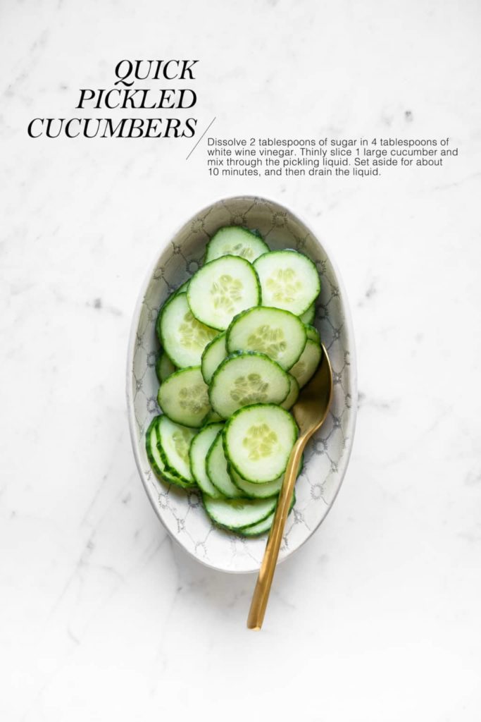 sliced cucumbers in bowl with gold spoon