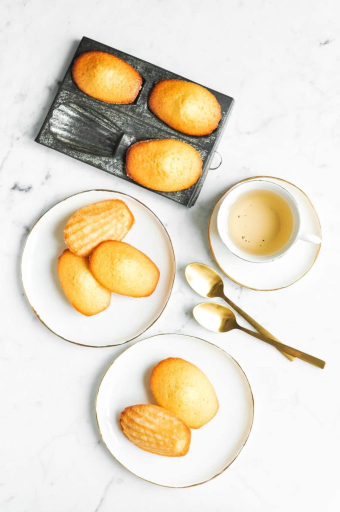madeleines on plate with cup of tea