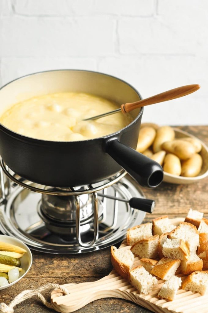 cheese fondue with slices of bread and new potatoes