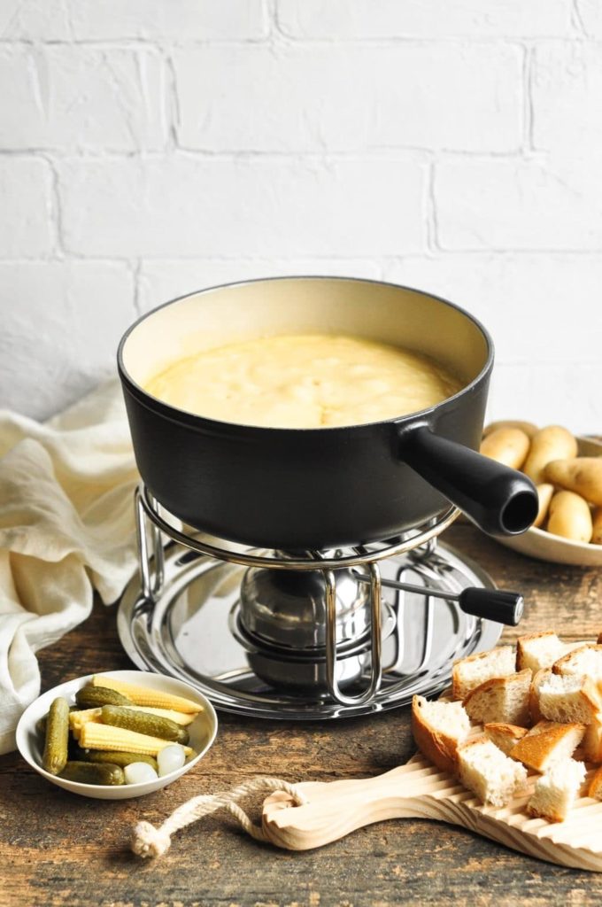 cheese fondue in black cast iron fondue pot