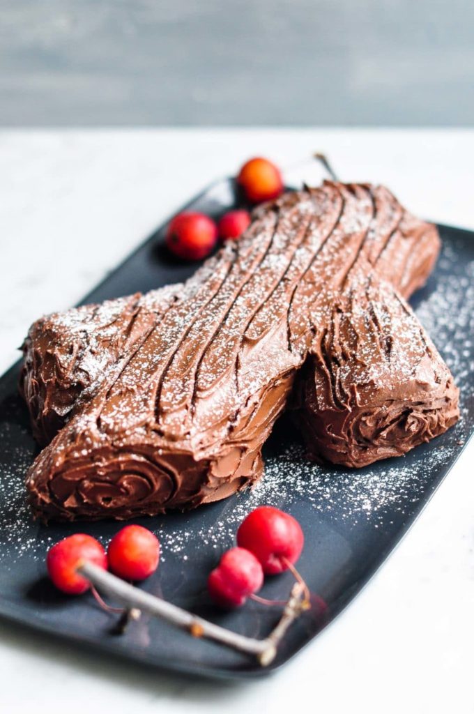 chocolate yule log with icing sugar on plate